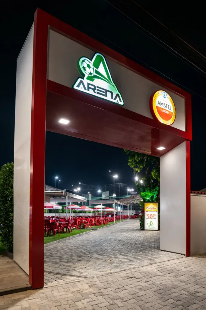 Entrada da Arena Show de Bola à noite, com o letreiro iluminado