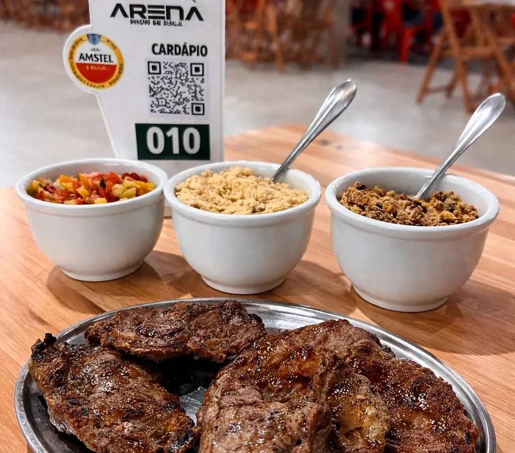 Churrasco servido com farofa, vinagrete e feijão tropeiro