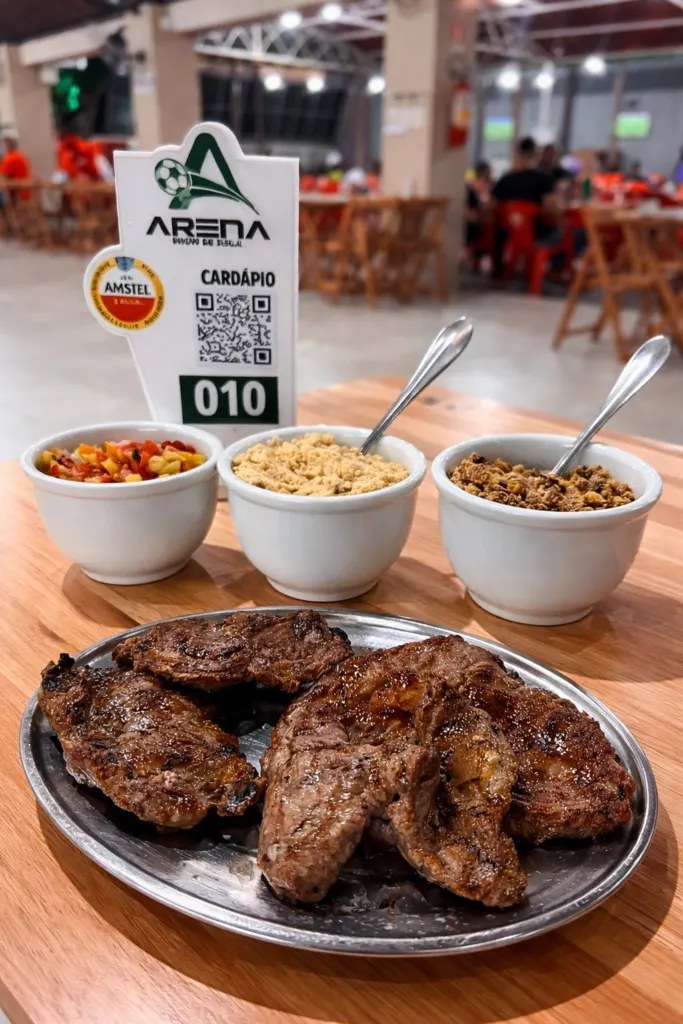 Churrasco servido com farofa, vinagrete e feijão tropeiro